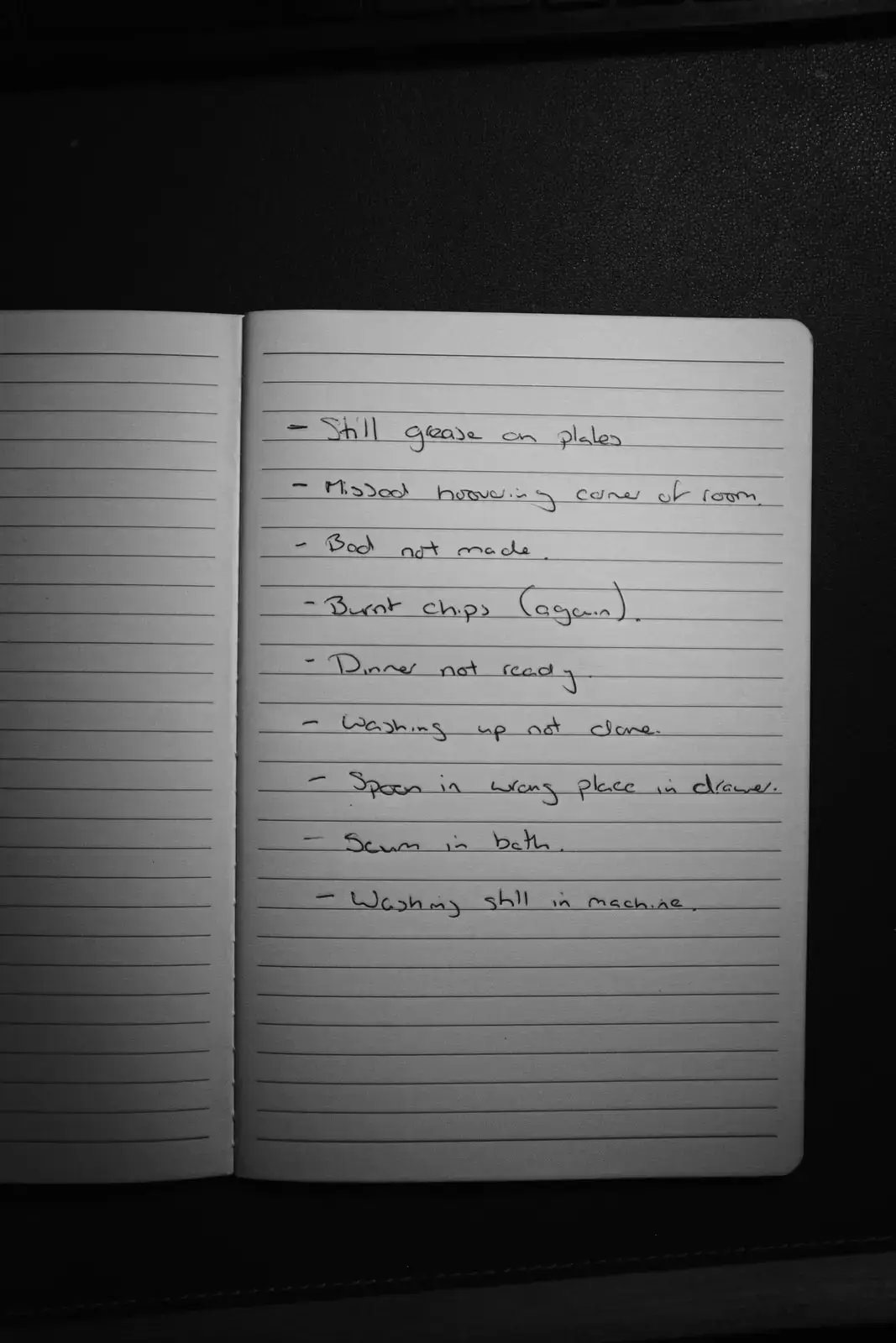 A handwritten checklist in a notebook listing household “failures” such as “Still grease on plates” and “Bed not made”