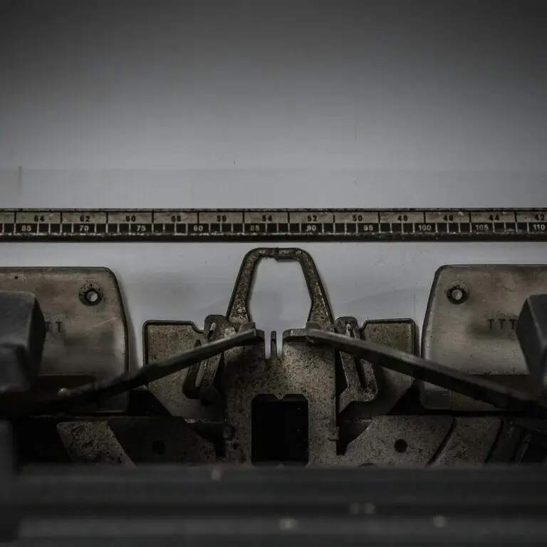 Close-up of an old typewriter’s carriage and metal components, focused on the ruler and central mechanisms.