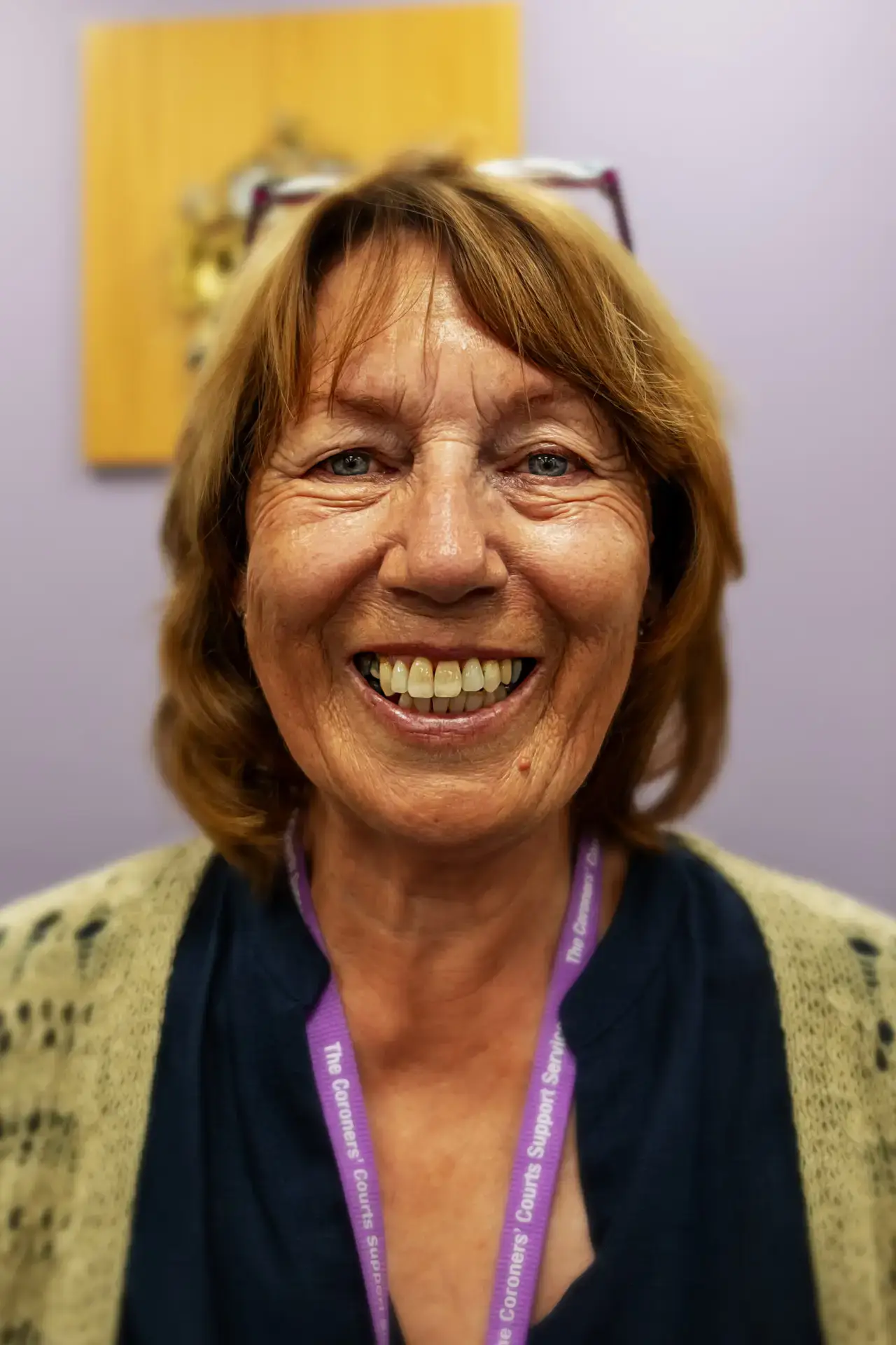 Smiling woman wearing a Coroners Courts Support Service lanyard.