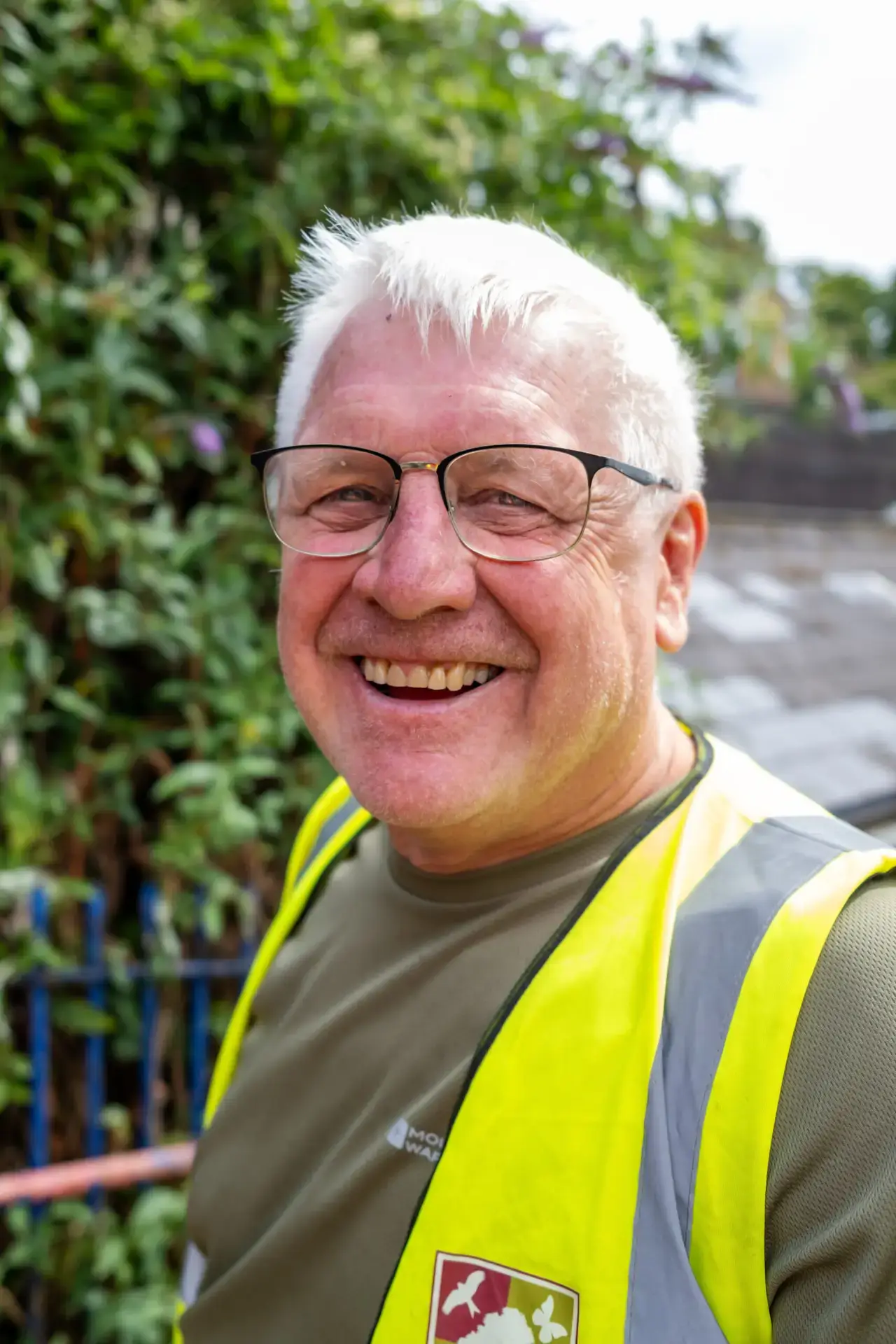 Smiling volunteer in high-visibility vest outdoors