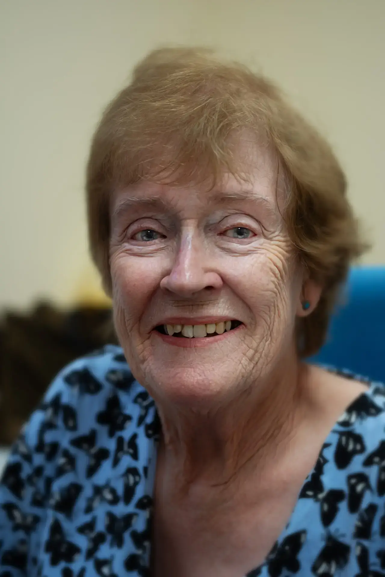 Smiling older woman with short hair wearing a patterned blouse
