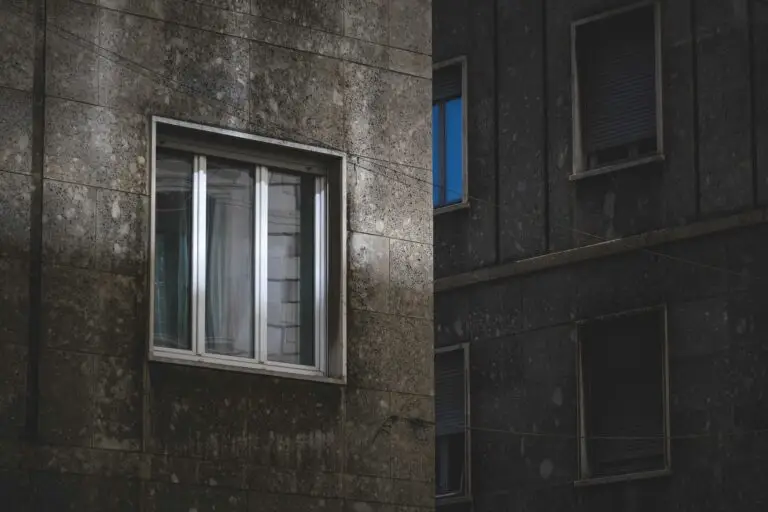 Close-up of concrete apartment building with windows in light and shadow
