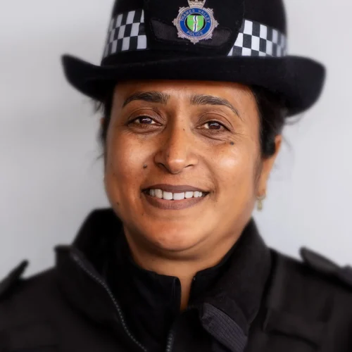 Smiling police officer in Thames Valley Police uniform with checked hat band